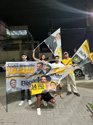 Grupo reunido com uma faixa em uma ação noturna