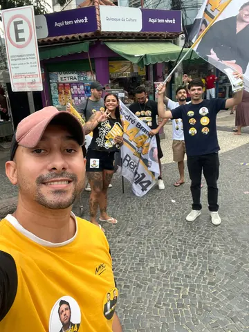 Participantes com bandeiras em frente ao comércio