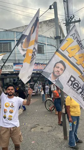 Participantes com bandeiras ao lado de barracas de comércio