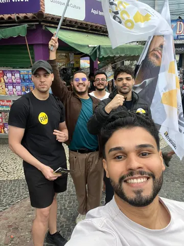Grupo reunido com bandeiras junto ao comércio