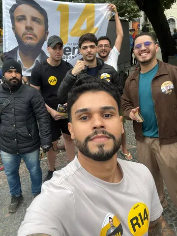 Grupo reunido com bandeiras e faixa de campanha