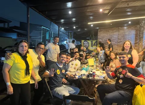 Grupo reunido no Happy Hour com bandeiras e camisetas da campanha