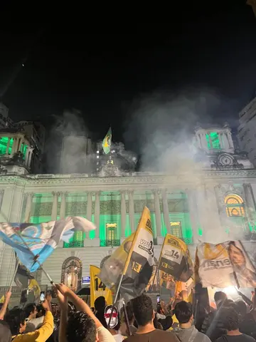 Manifestação noturna com participantes e bandeiras